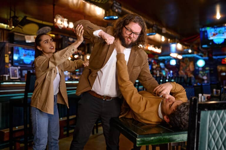 Young woman trying to separate craze mad fighting friends